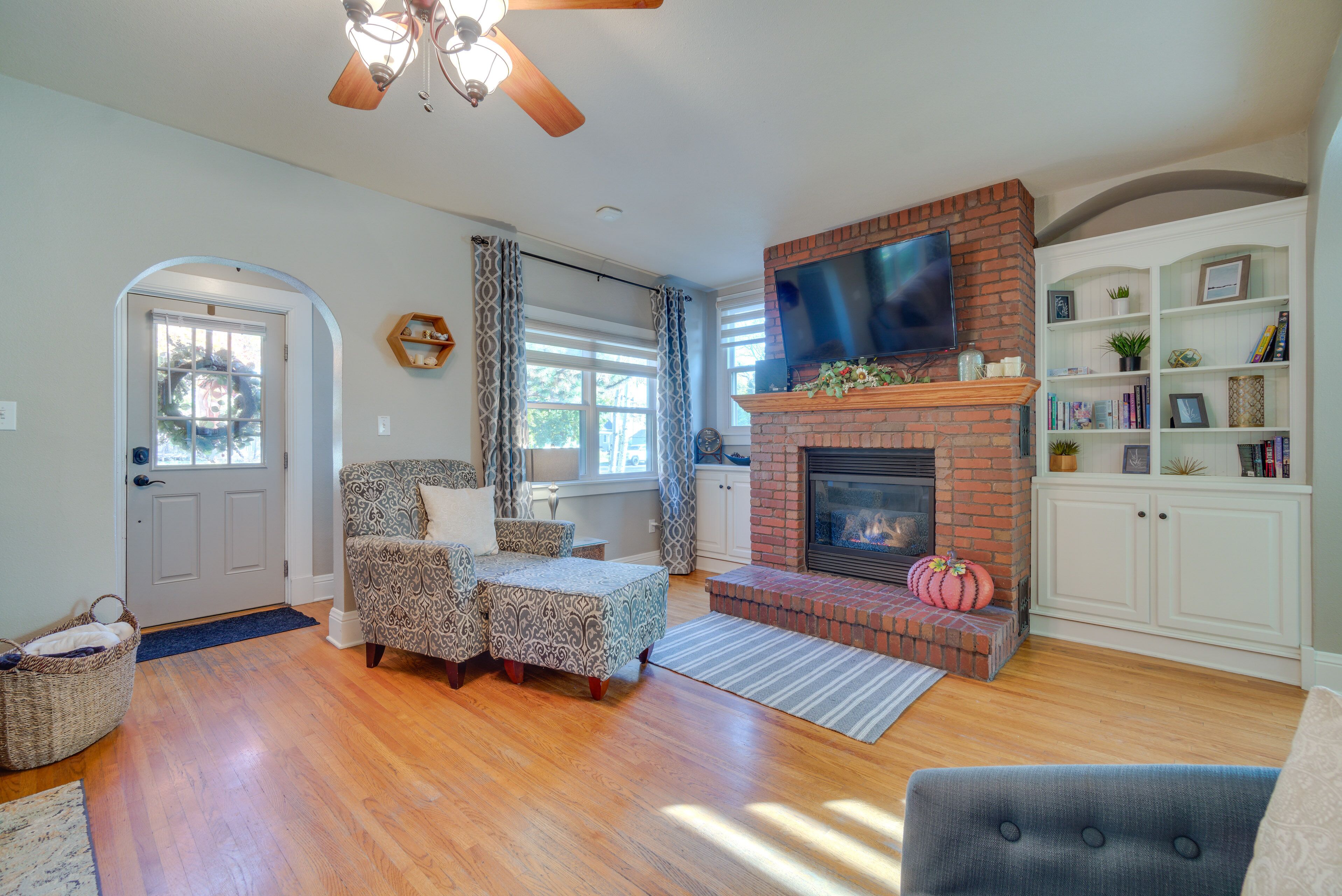 A living room with a fireplace, a television, and a bookshelf.