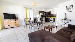 A modern living room with a flat-screen TV, wooden furniture, and a dining area with chairs and a table. - High-end detached house, in a small village on the island of Oleron (Dolus d'Oleron au hamlet les Bardieres at 4 grande rue) in a charming property. (Dolus-d'Oléron)