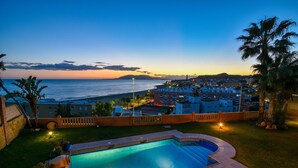 Una piscina con vistas al mar y edificios al fondo.