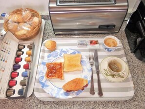 A breakfast tray with toast, jam, and tea, a toaster, and a basket of bread rolls. - Balcon de La Cala (Rincon de la Victoria)