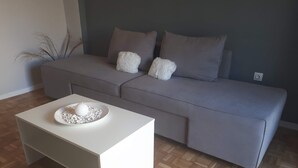 A modern living room with a grey sofa, a white coffee table, and a wooden parquet floor. - A nice apartment in corfu town (Corfu)