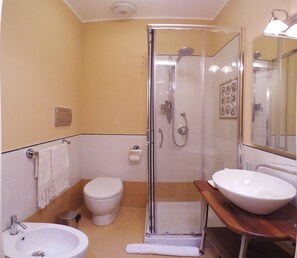 Een douche, een haardroger, een bidet, handdoeken