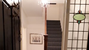 A staircase with a checkered floor leading to a door with a stained glass window. - Delightful Victorian House (Belfast)