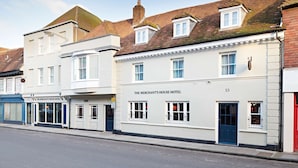 Rivissä on useita rakennuksia, ja oikealla puolella niistä sijaitsee huomiota herättävä hotelli nimeltä ”The Merchant’s House Hotel”. Rakennuksessa on perinteinen julkisivu, jossa on useita ikkunoita ja sininen ovi.
