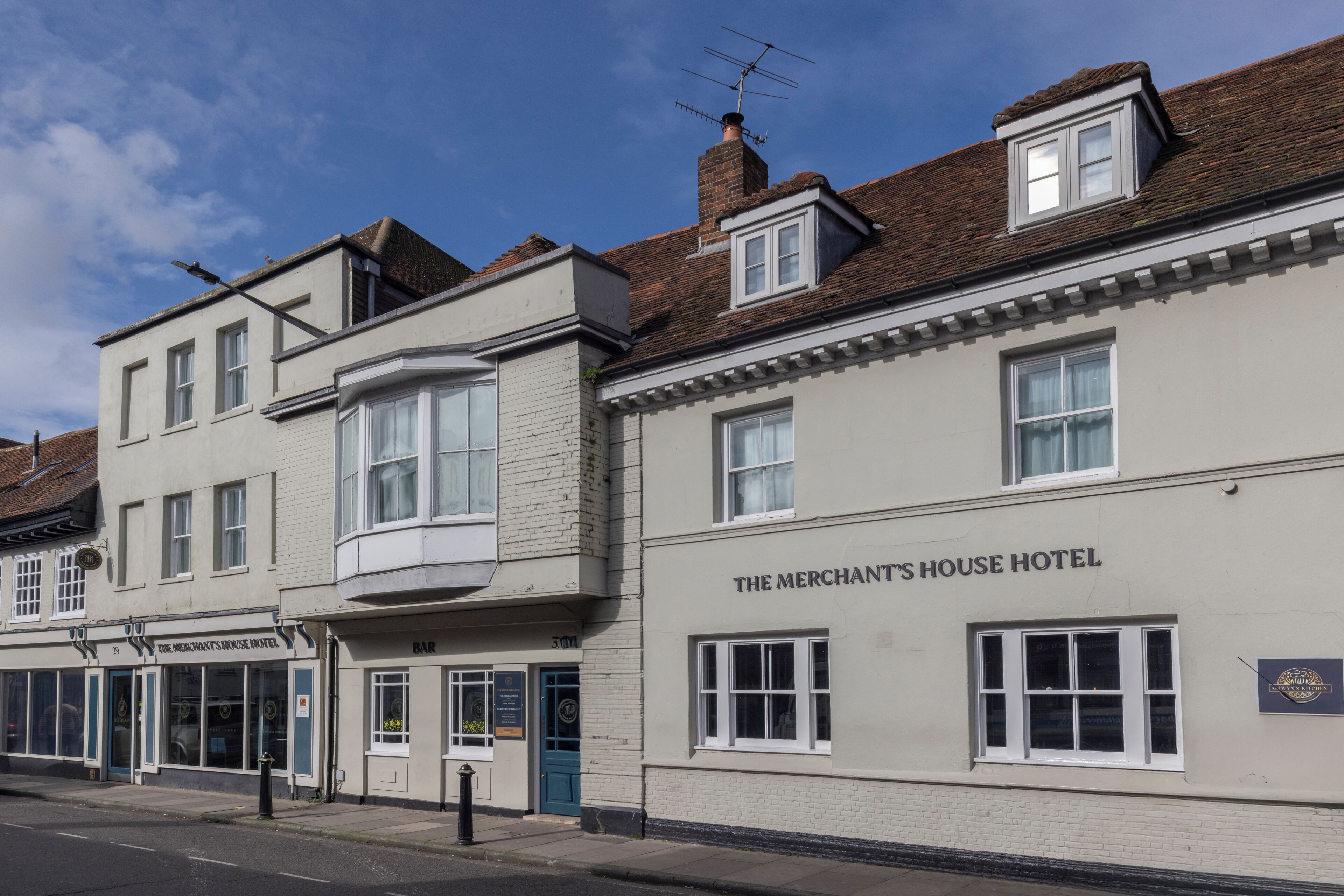 A building labeled 'The Merchant's House Hotel' with a bar, multiple windows, and a chimney.