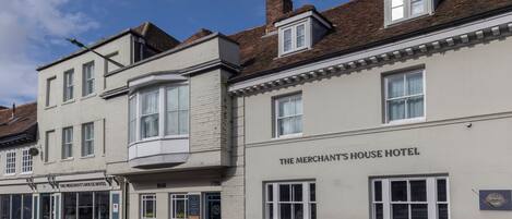 A building labeled 'The Merchant's House Hotel' with a bar, multiple windows, and a chimney.