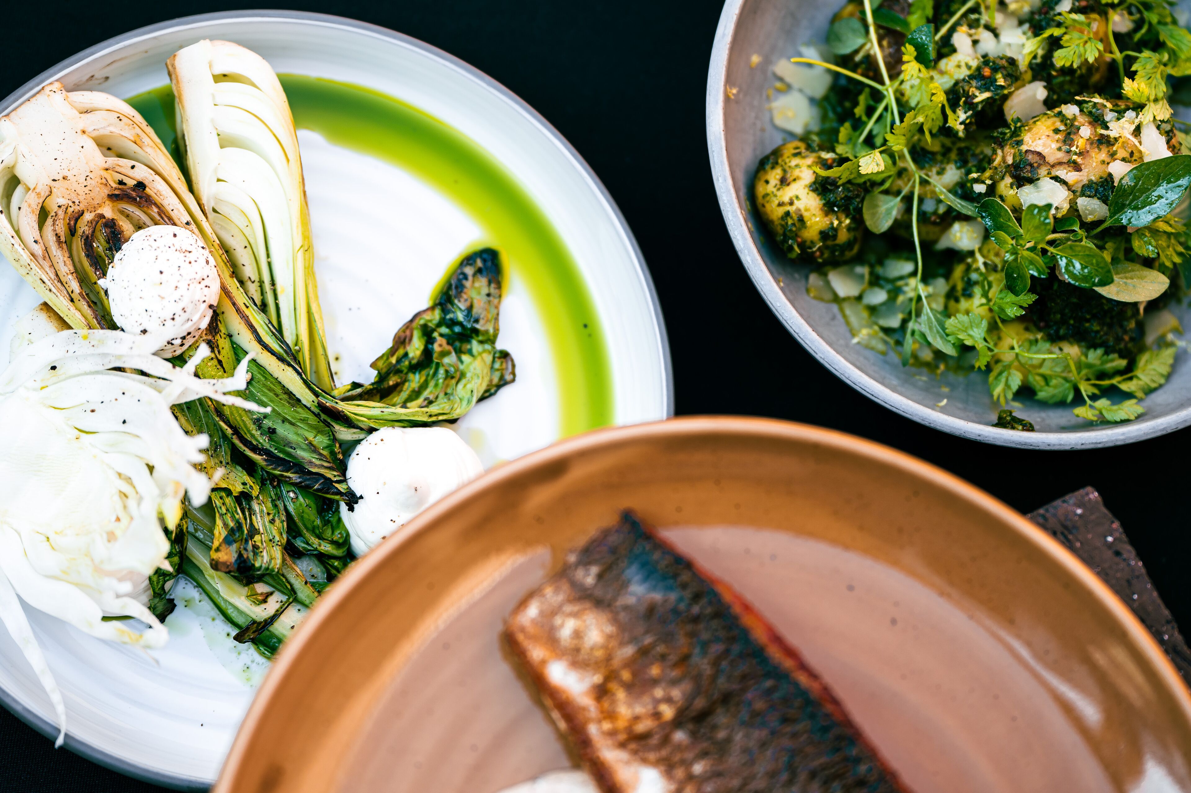 Une assiette de nourriture contenant divers légumes et un morceau de poisson.