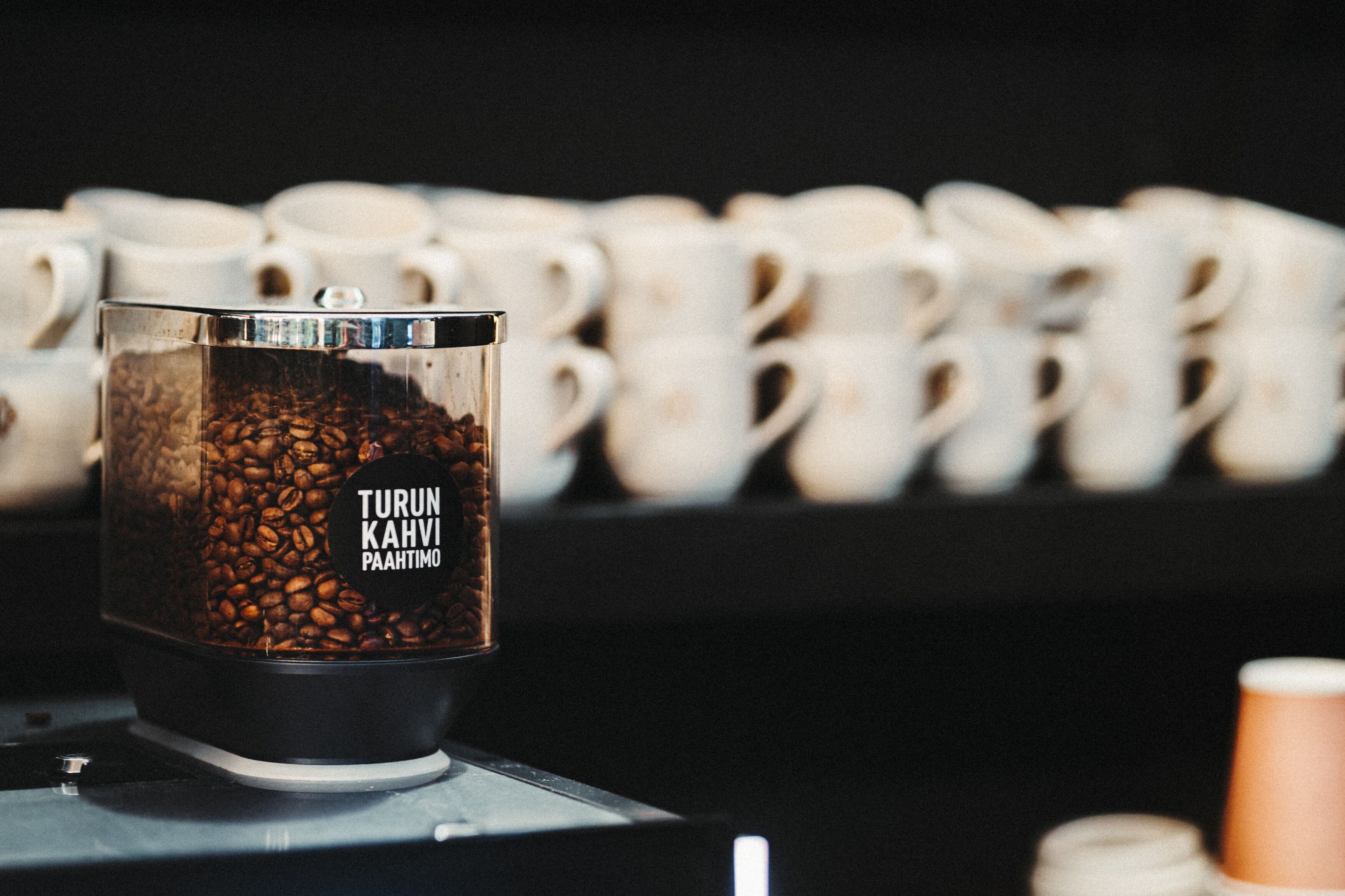 A coffee grinder with visible coffee beans and a label reading "Turun Kahvi Pahtimo".