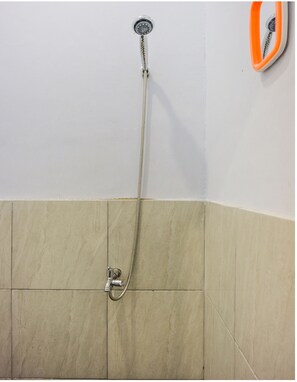 A bathroom with a shower, a toilet, and a sink. - OYO 2277 Lulu Homes (Makassar)