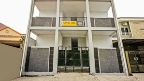 A multi-story building with a balcony on the second floor, a gated entrance, and a sign indicating it is a spot on Lulu Homes. - OYO 2277 Lulu Homes (Makassar)