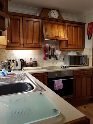 Departamento familiar, 2 habitaciones, planta baja | Cocina privada | Refrigerador con congelador, microondas, horno y parrilla de estufa