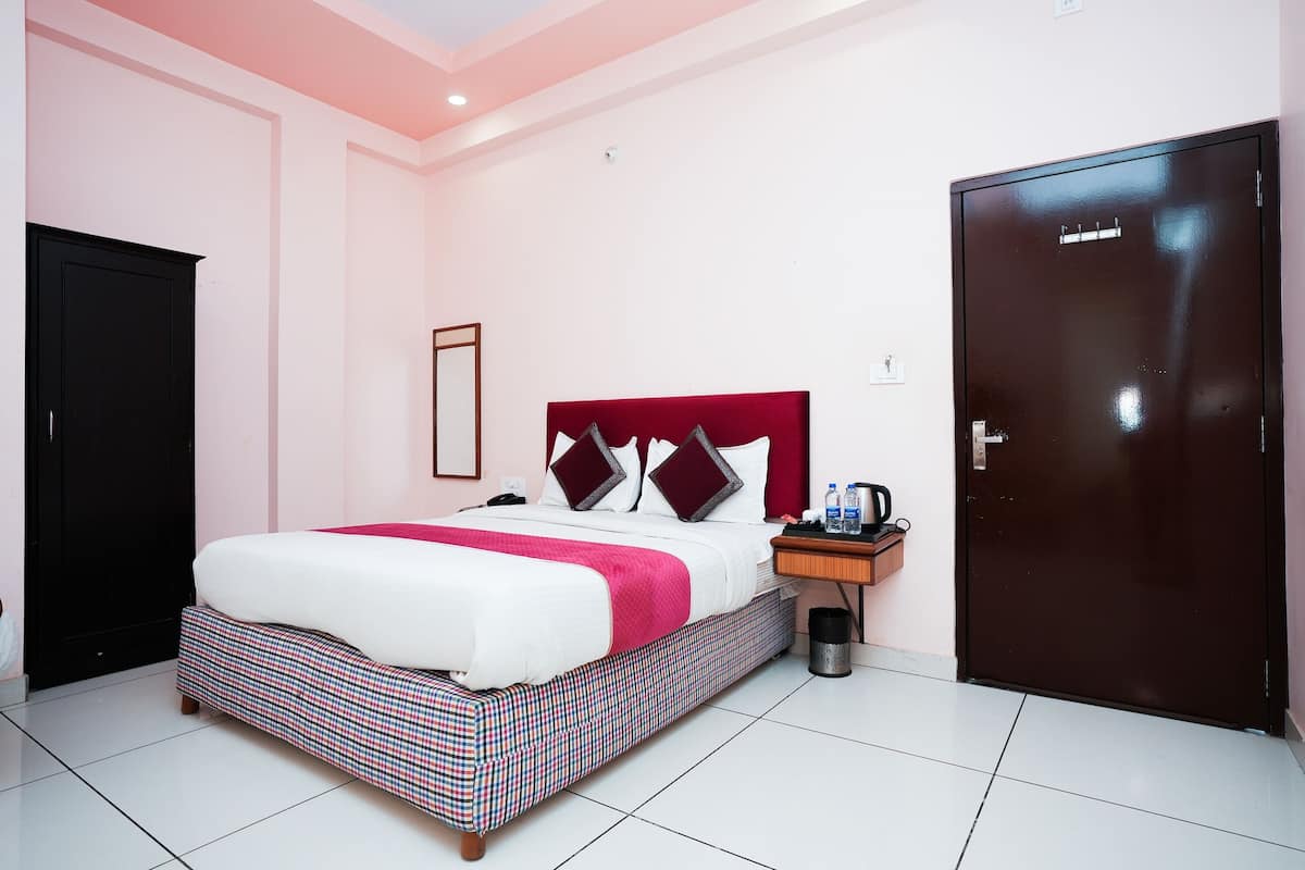 A hotel room with a bed, a nightstand, a wardrobe, and a door.