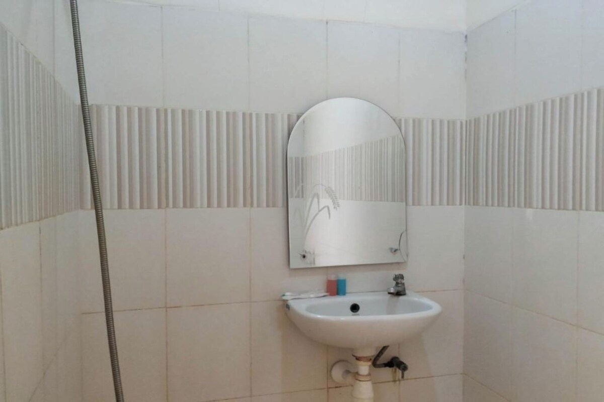 Ein Badezimmer mit einem weißen Waschbecken, einem Spiegel und einer Duschvorhang.