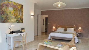 A bedroom with a bed, bedside tables, a desk, and a chair. There is a painting on the wall and a lamp on the desk. - Logis du Parc (Saint-Fulgent)