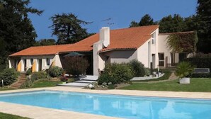 A two-story house with a swimming pool, surrounded by a well-maintained garden and trees. - Logis du Parc (Saint-Fulgent)