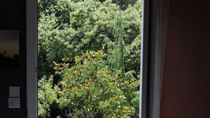 A room with a large window opening to a garden. - Logis du Parc (Saint-Fulgent)