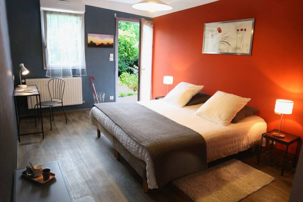Une chambre à coucher avec un lit, des tables de chevet, un bureau et une chaise.