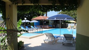 A poolside area with lounge chairs, umbrellas, and a bar. - Dalyan Summer Life Apart Hotel (Ortaca)
