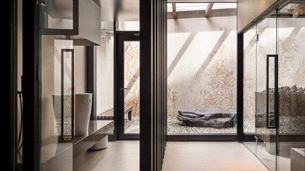A modern interior with a glass partition, a bench, and a rock garden. - SCHLOSS Zermatt - CBD & Adaptogenic Spa and Sport Hotel (Zermatt)