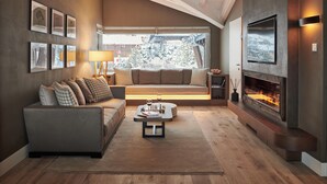 A modern living room with a sofa, coffee table, fireplace, and artwork on the walls. - SCHLOSS Zermatt - CBD & Adaptogenic Spa and Sport Hotel (Zermatt)