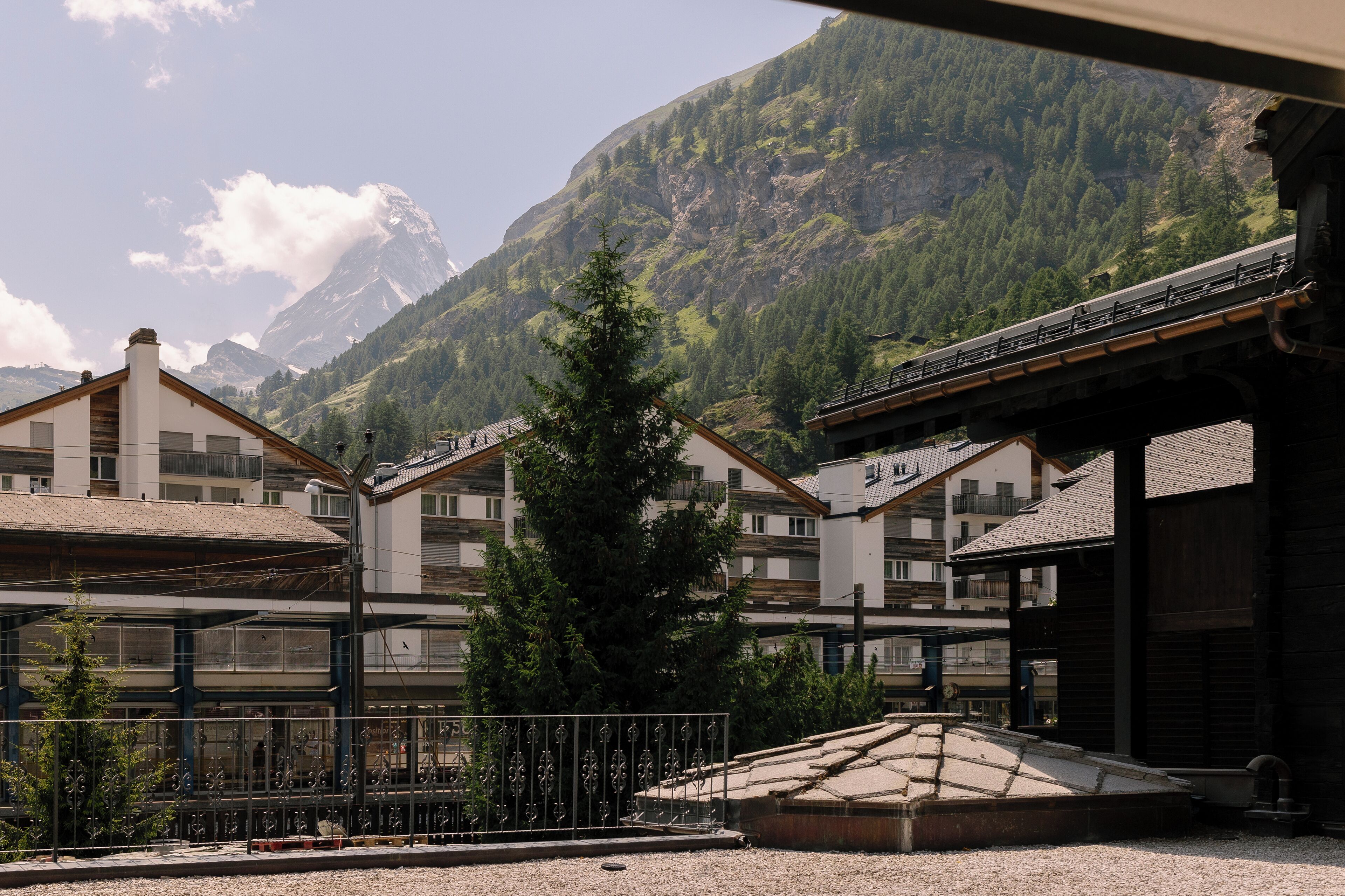 A building with a traditional architectural style, featuring a prominent wooden roof and a balcony.