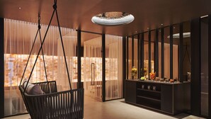 A modern interior with a hanging chair, a bar area with bottles, and a view through sheer curtains. - SCHLOSS Zermatt - CBD & Adaptogenic Spa and Sport Hotel (Zermatt)