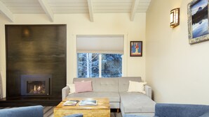A living room with a fireplace, a sofa, and two armchairs. - Experience the best of Ketchum-living in a newly remodeled mountain modern condo (Ketchum)