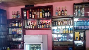 A bar with shelves of various liquor bottles and a refrigerator filled with drinks. - Escarpment Motel - Adults Only (Mai Mahiu)