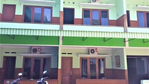 A multi-story building with balconies, windows, and air conditioning units. - Hotel Mulia (Baki)