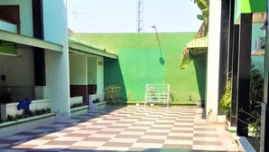 A courtyard with a checkered floor, a green wall, and a badminton net. - Hotel Mulia (Baki)