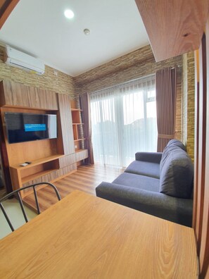 A modern living room with a wooden TV stand, a sofa, and a dining table.