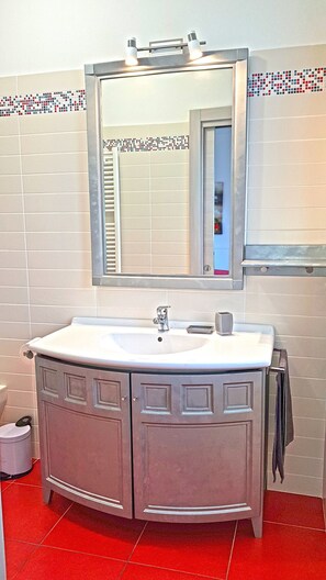 A bathroom with a white sink, a mirror, and a cabinet.