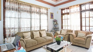 A living room with two sofas, a coffee table, and a laptop on a wooden floor.