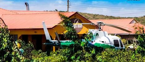 Um helicóptero estacionado em frente a um edifício com uma placa que diz "KENTY".