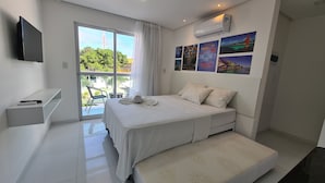A modern bedroom with a bed, a small desk, and a TV. - Porto Sol Flats by AFT (Ipojuca)