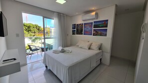 Ein Hotelzimmer mit Bett, Schreibtisch, Stuhl und Blick ins Freie.