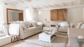 Amplia sala de estar con sofá blanco, una mesa de centro y un aparador de madera.