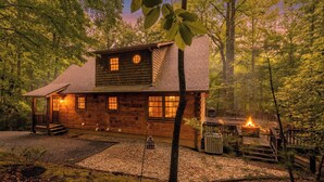 Une cabane avec une véranda, un foyer extérieur et une terrasse.