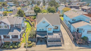 A residential area with houses, a small driveway, and a clear view of the surrounding neighborhood. - Spacious Beach Home for the whole family, 2 Blocks to Beach/Seaside Promenade (Seaside)