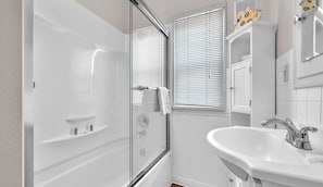 A modern bathroom with a glass-enclosed shower, a white sink, and a vanity with a mirror. - Spacious Beach Home for the whole family, 2 Blocks to Beach/Seaside Promenade (Seaside)