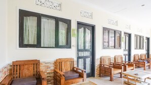 A room with wooden furniture, including chairs and a table, arranged for guests. - Green View Ubud Hostel Bali (Ubud)