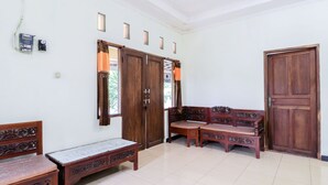A room with a wooden bench, a sofa, and a door.