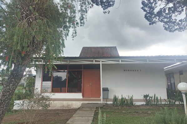 A modern building with a large glass door, a metal roof, and a sign that reads "MIRANDA'S". - Kaliaga Bungalow (Berastagi)