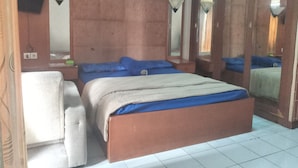 Ein Schlafzimmer mit einem Bett, einem Sessel und einem Spiegel.