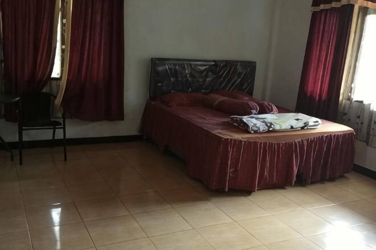 Ein Zimmer mit Bett, Stuhl und Heizkörper.