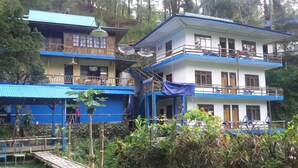 Un edificio de dos pisos con balcones, parabólicas y una zona de estar cubierta al aire libre.