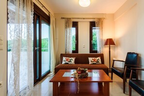 A room with a sofa, a table, a lamp, and a chair.