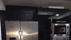A modern kitchen with a stainless steel refrigerator, a built-in oven, and a microwave. - Rental apartment close to all services. (Bouzareah)