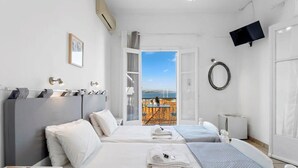 A hotel room with two beds, a TV, a ring light, and a view of the beach. - Thalassa, Return To Timeless Spetses (Spetes)
