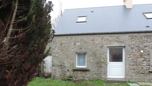A stone building with a door and a window. - Independent studio 25m² 800 m from the sea (Anneville-sur-Mer)